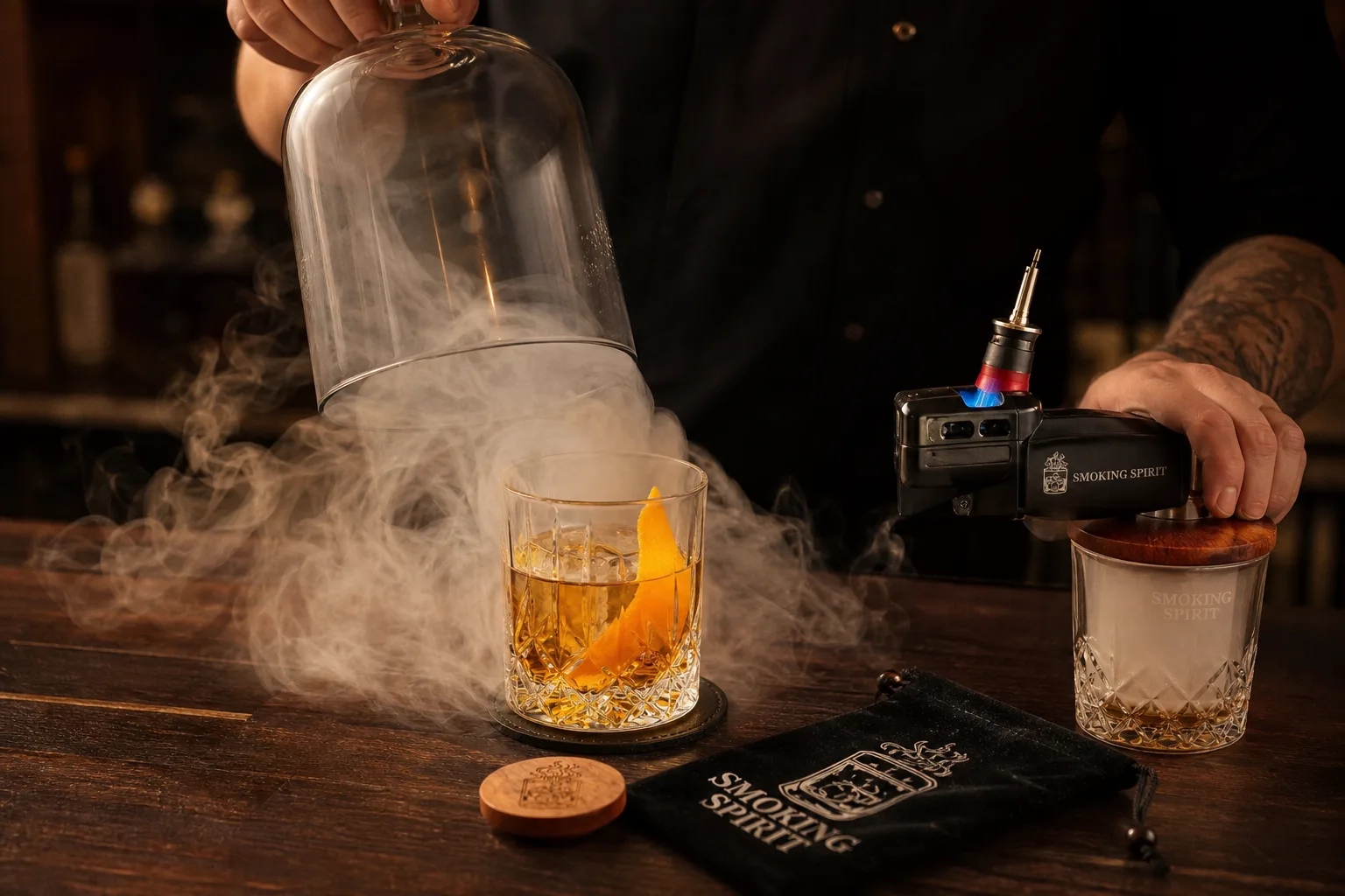 Sötét diófa bárpulton egy jégkockás whiskys pohár áll narancshéjjal, mellette parázsló faaprítékos füstölőpisztoly; a pultos épp felemel egy üvegbúrát, alóla sűrű fehér füst gomolyog a pohár körül, meleg oldalfényben.